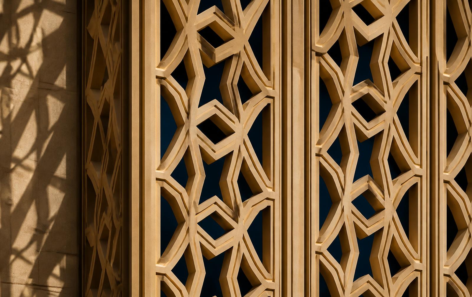 Detail of a sandstone geometric screen on a contemporary Gulf building facade